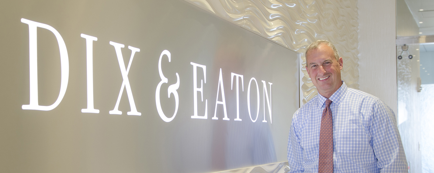 Chas Withers standing beside the Dix & Eaton sign at the firm’s office