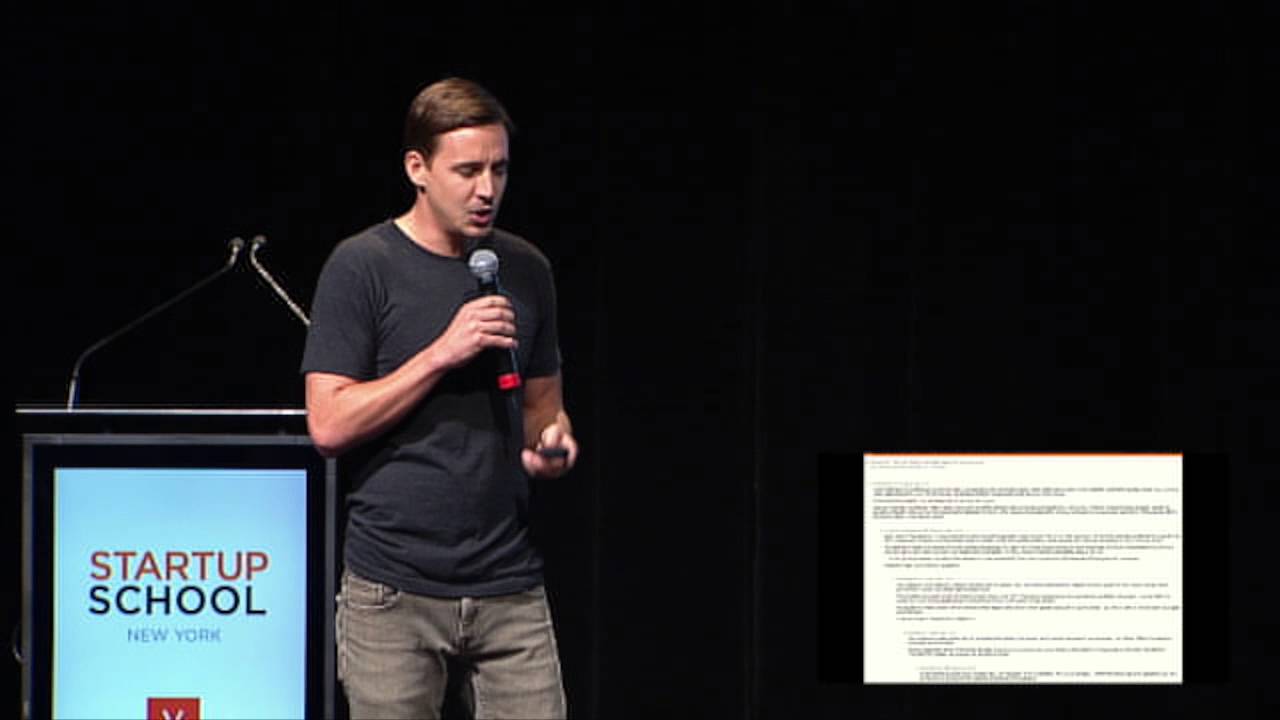 Chase Adam holding a microphone onstage at Startup School New York in 2014