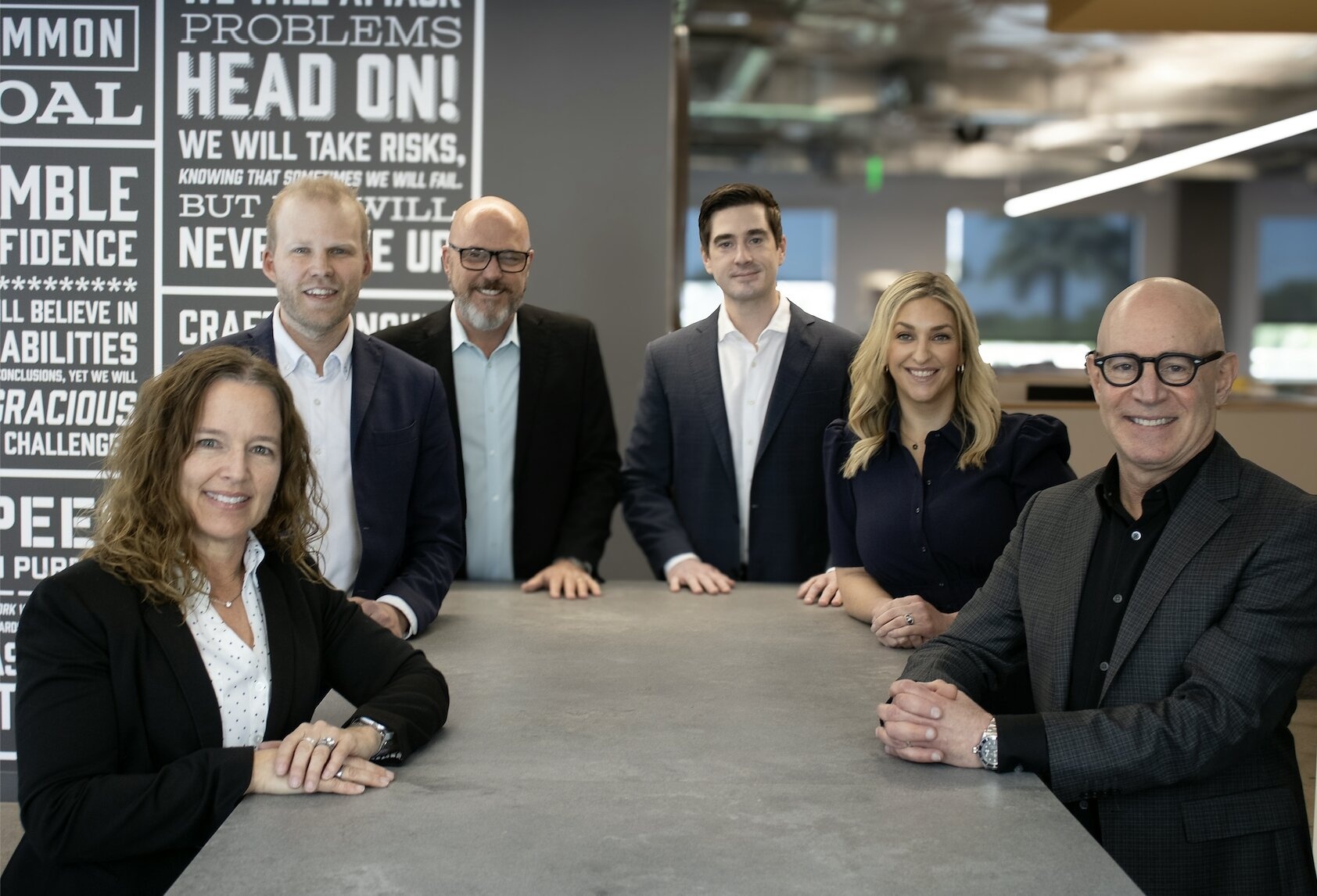 LT leadership team in the agency office; Chase Lane stands fourth from left