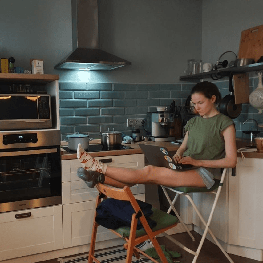 A Chatfuel remote team member working on a laptop from a kitchen