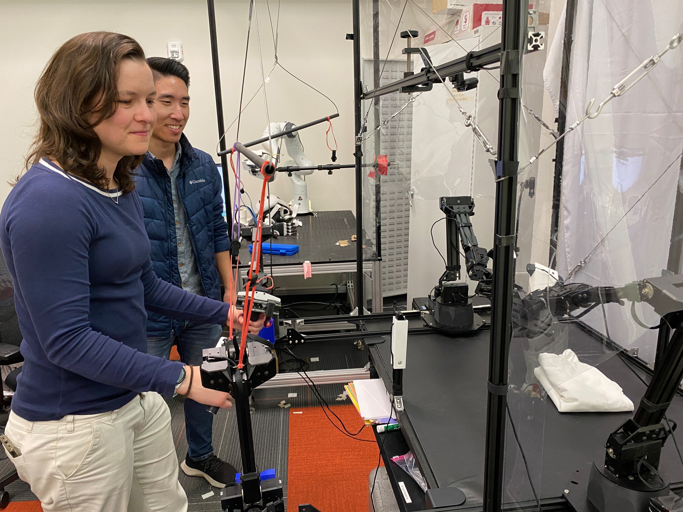 Chelsea Finn and Moo Jin Kim demonstrate a robot in a Stanford lab