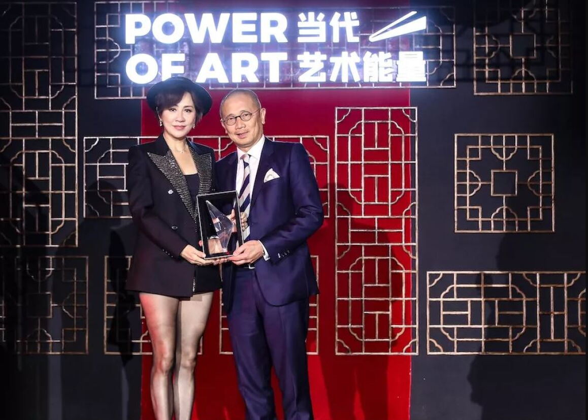 Kevin Ching, right, receiving an Asia Art Pioneers award from actress Carina Lau