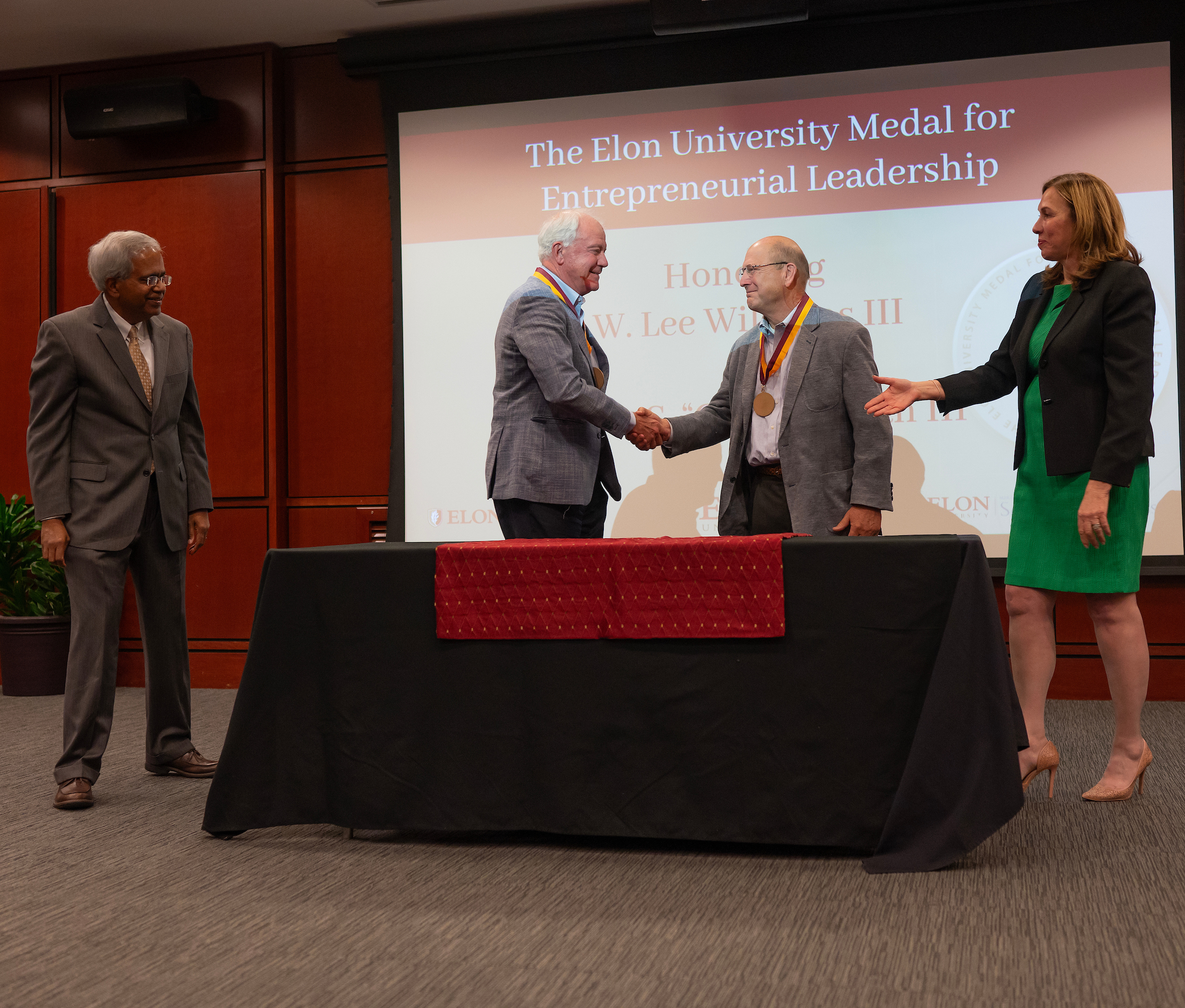 Chip Mahan, second from left, shakes hands with Lee Williams at Elon’s entrepreneurial leadership medal ceremony