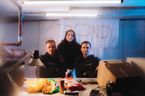 Chloe Samaha with BOND co-founders Flor Sanders and Tibo Wiels in front of a handmade BOND sign