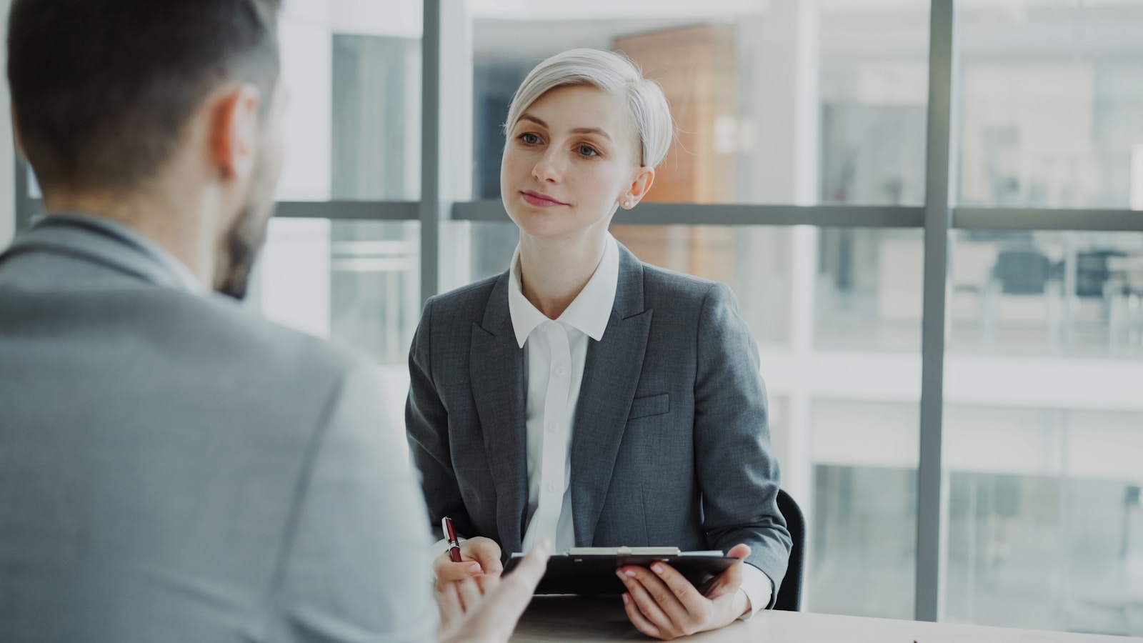 A recruiter listens to a candidate during an office interview