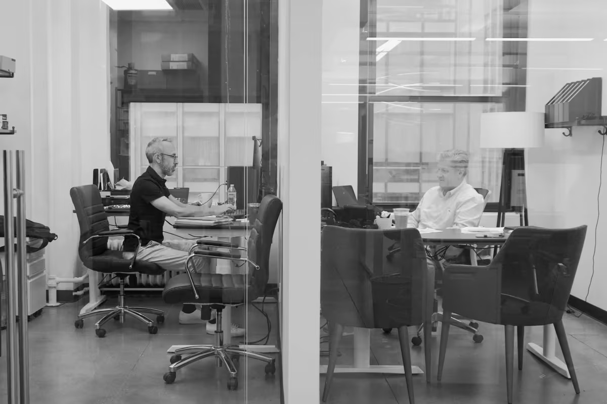 Chris Ainsworth, right, and Head of Trading Kevin Berkowitz working in a glass-walled Pave office