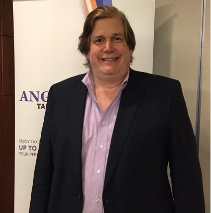 Chris Burry standing at an event, wearing a dark jacket and an open-collar shirt
