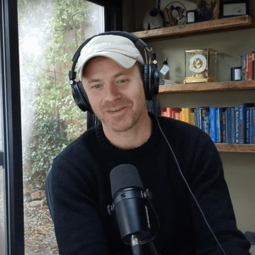 Chris Faught wearing headphones and speaking into a microphone during a podcast appearance