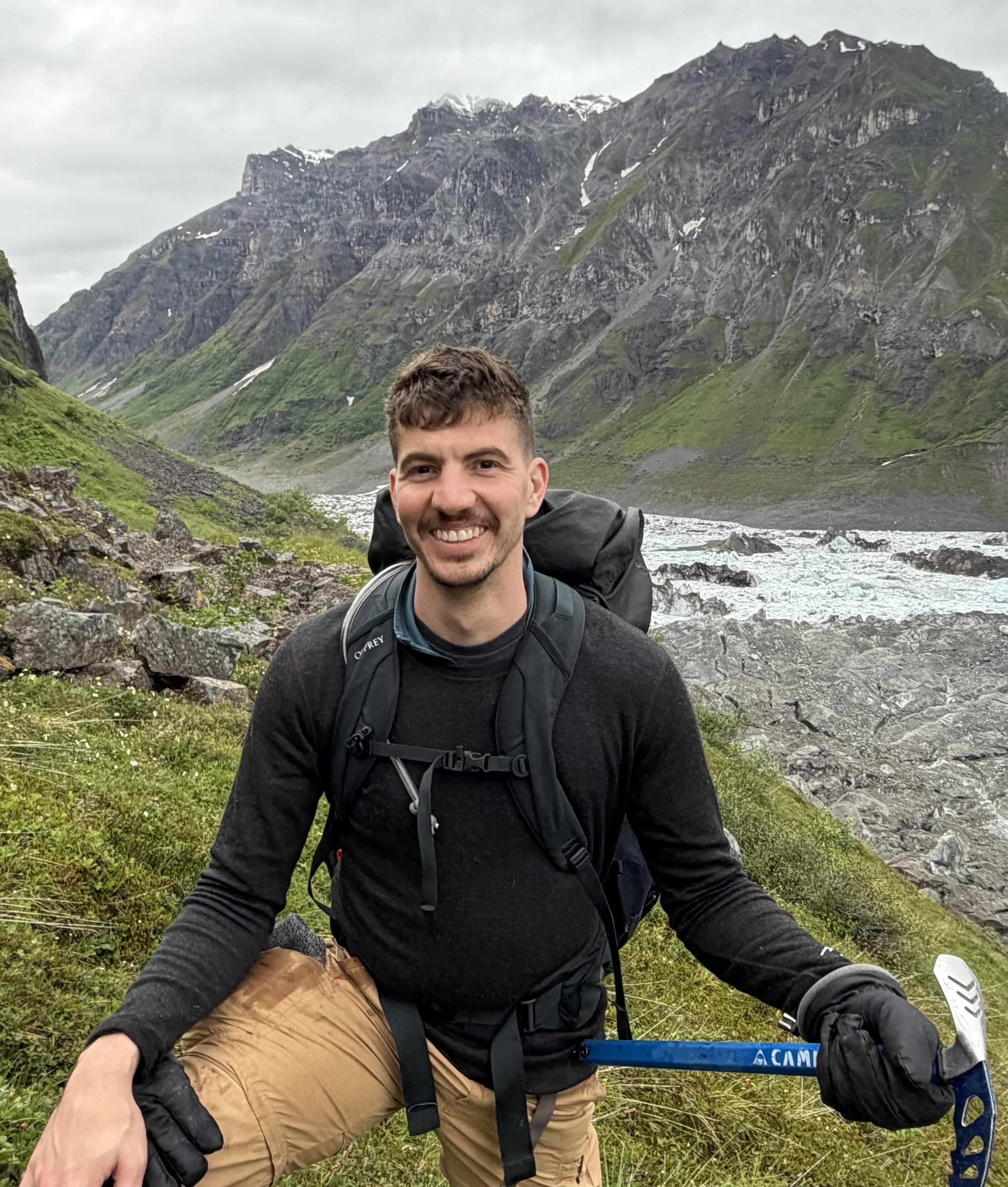 Chris Heinrich smiling on a mountain trail in Alaska