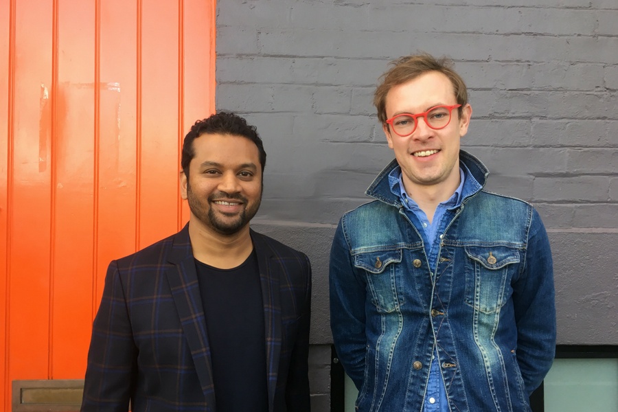 Investor Tushar Roy, left, and Chris Hexton, right, standing outside beside an orange door