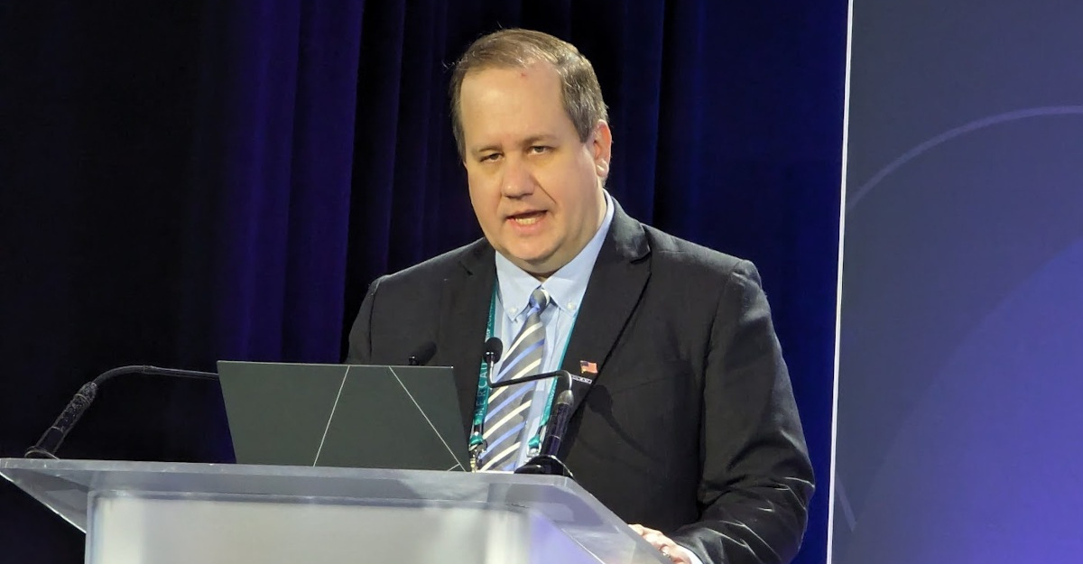 Chris Riegel speaking at a lectern during an industry event