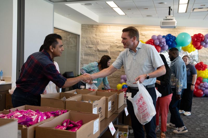 Chris Turner shaking hands with a colleague beside tables of supplies
