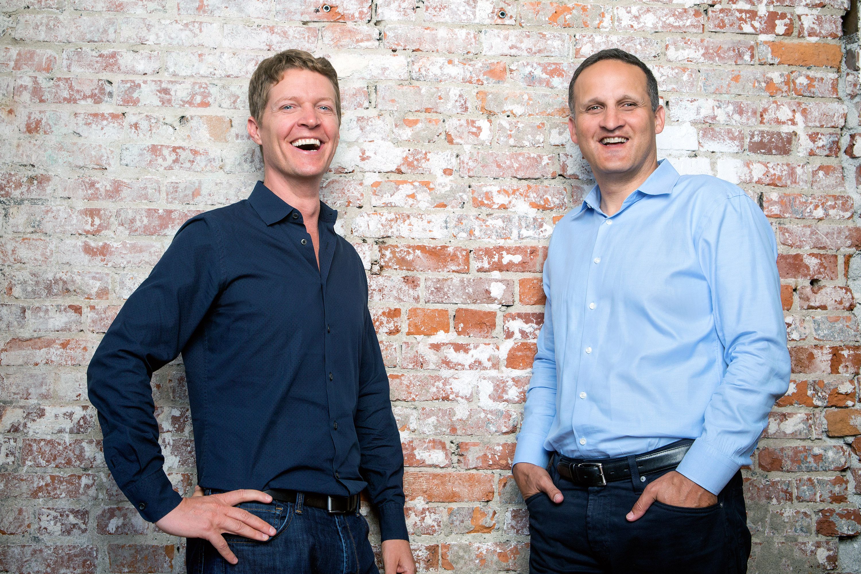 Christian Chabot, left, and incoming Tableau CEO Adam Selipsky laughing beside a brick wall