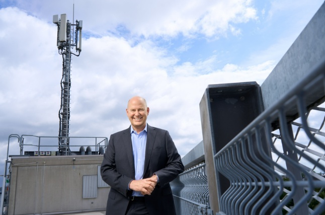 Christian Hillabrant standing beside telecommunications equipment on a rooftop