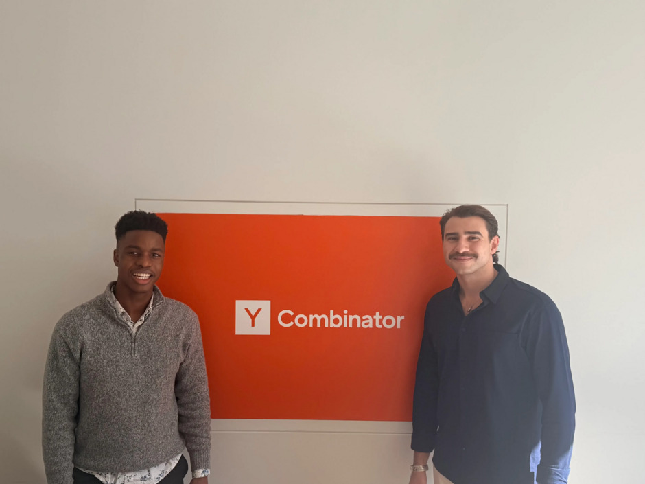 Christian Pickett and Bera Sogut standing beside a Y Combinator sign