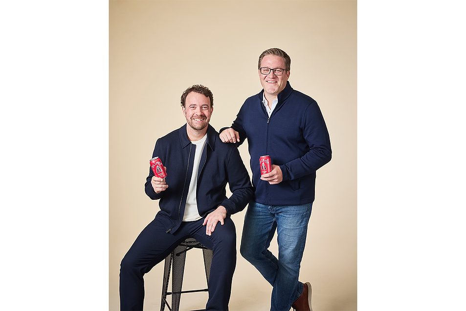 OLIPOP founder Ben Goodwin and chief executive Christian Patiño Webb pose together holding red cans