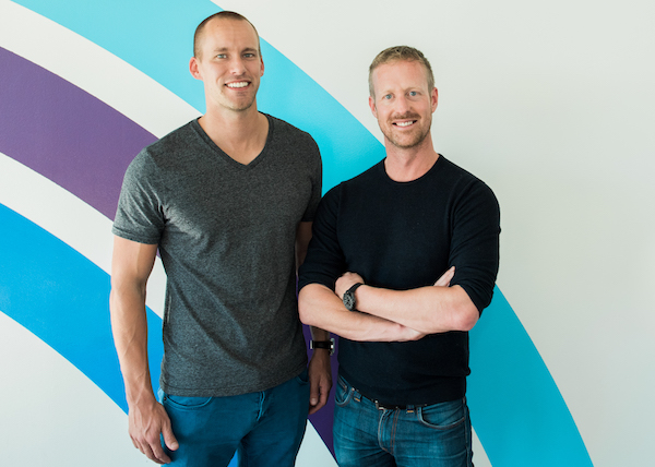Christian Wiklund, left, and Niklas Lindstrom standing together in front of a colorful wall