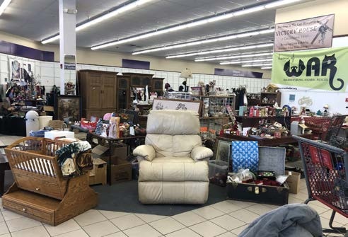 Rows of donated furniture and household goods fill the Warrensburg charity garage sale floor