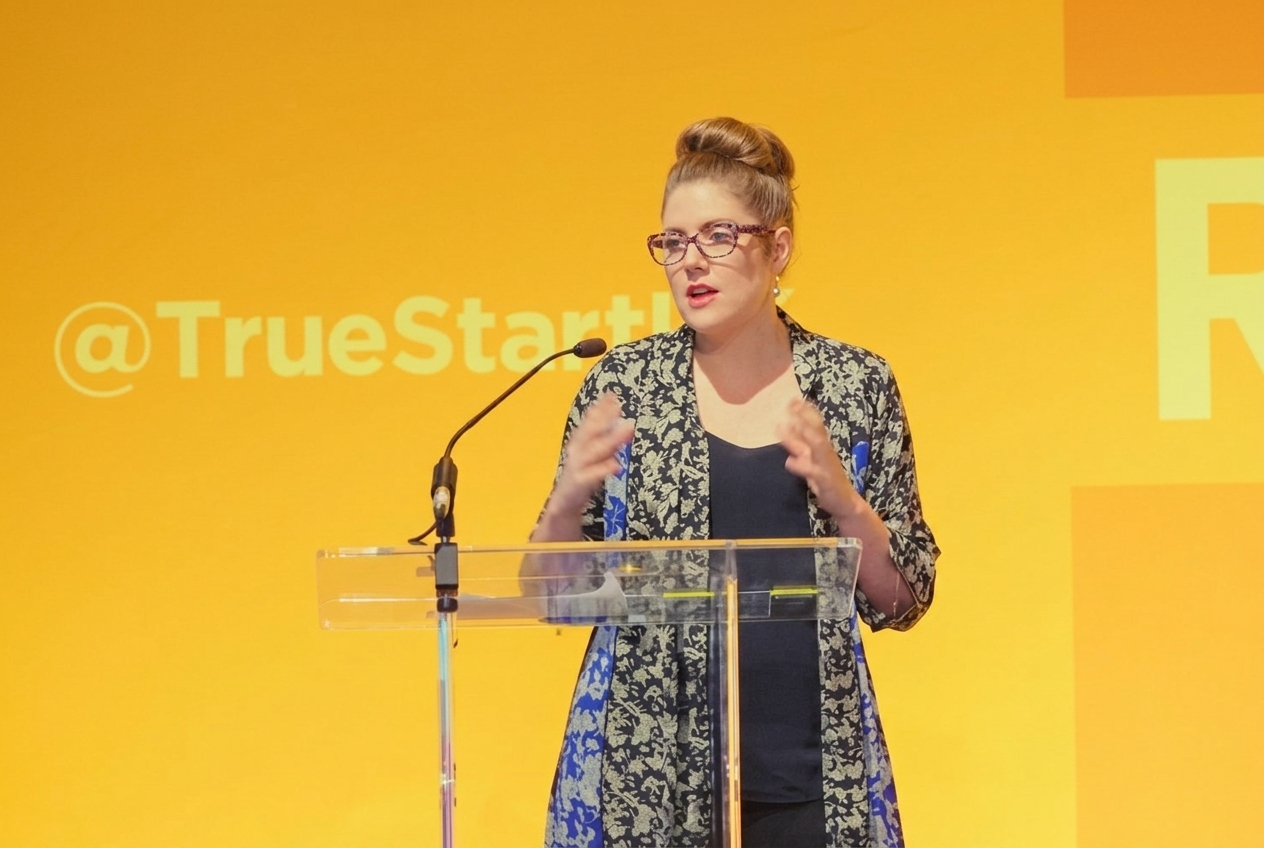 Christine Hunsicker speaking behind a clear lectern at the 2017 R: Evolution 4.0 event