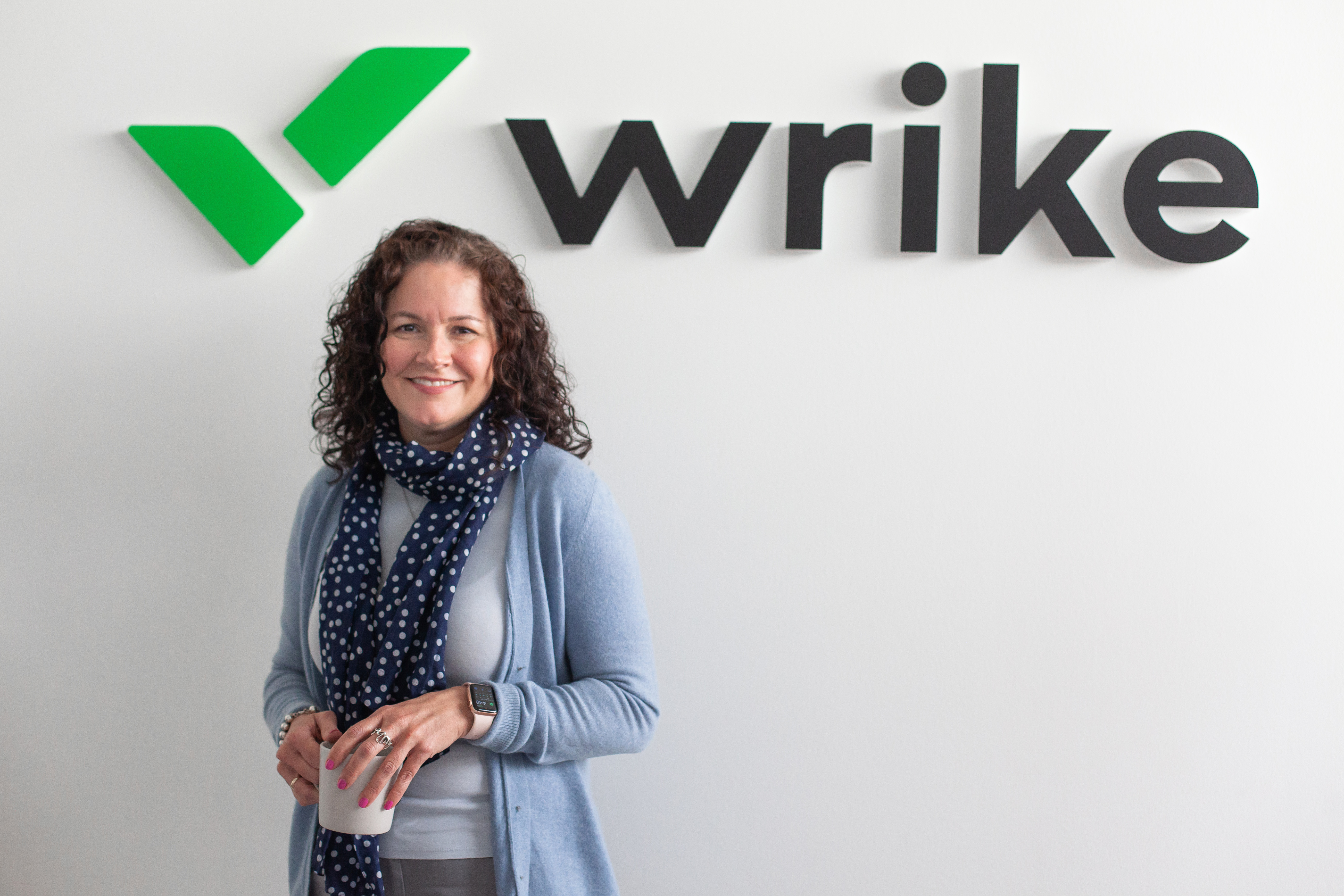 Christine Royston standing beneath the Wrike wordmark