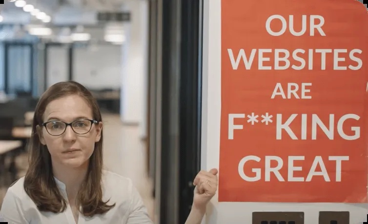 Christine Telyan in an office beside the orange sign used in UENI’s website advertisement