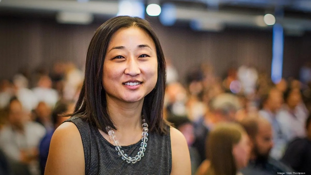 Christine Tsai photographed with a busy gathering behind her