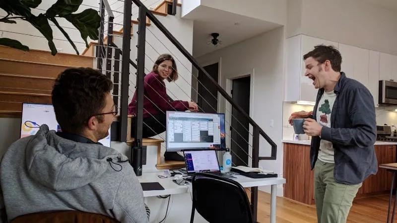 Early Slite colleagues talking around laptops in a shared working space