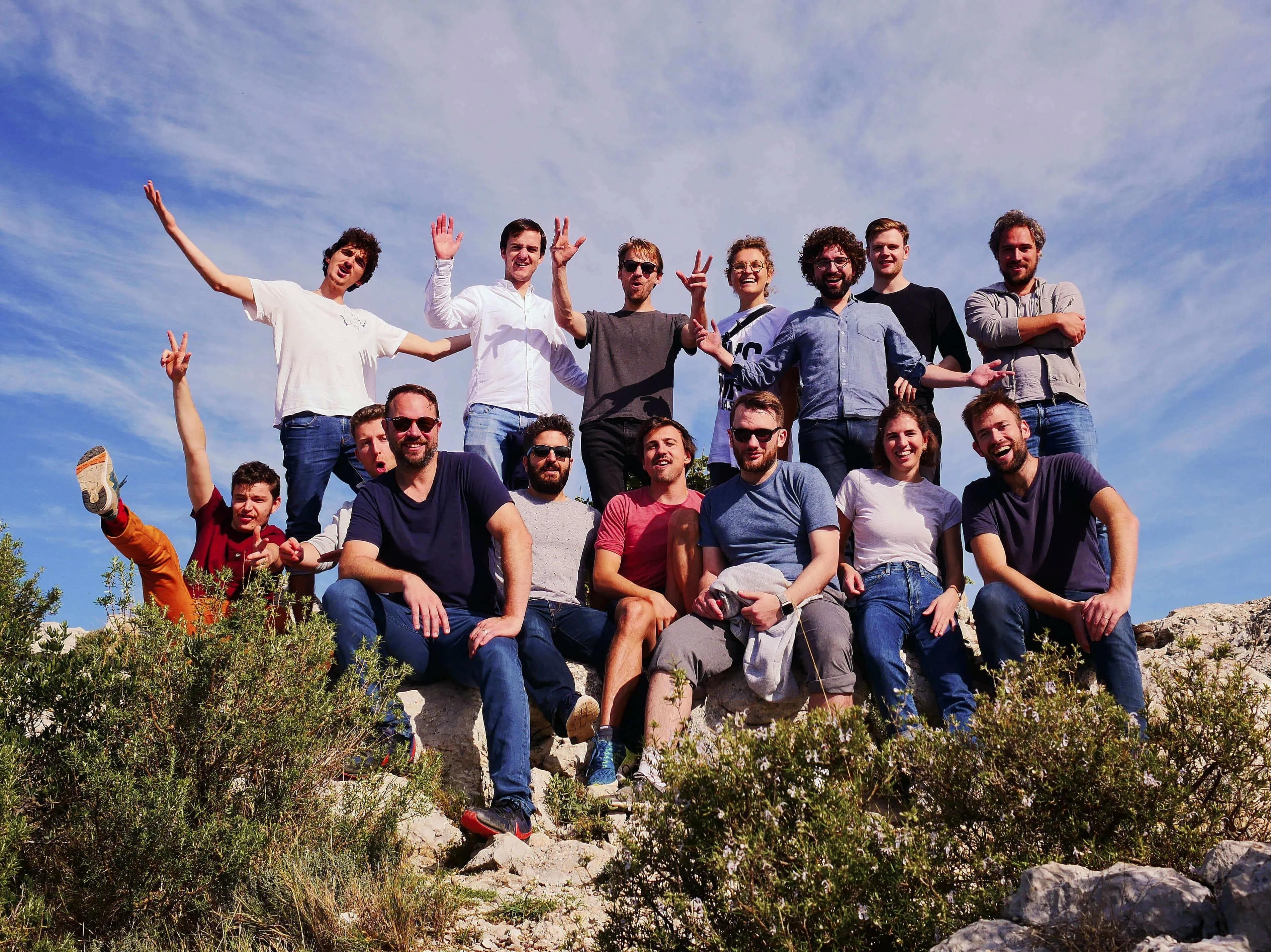 Slite colleagues gathered outdoors on a rocky hillside beneath a blue sky