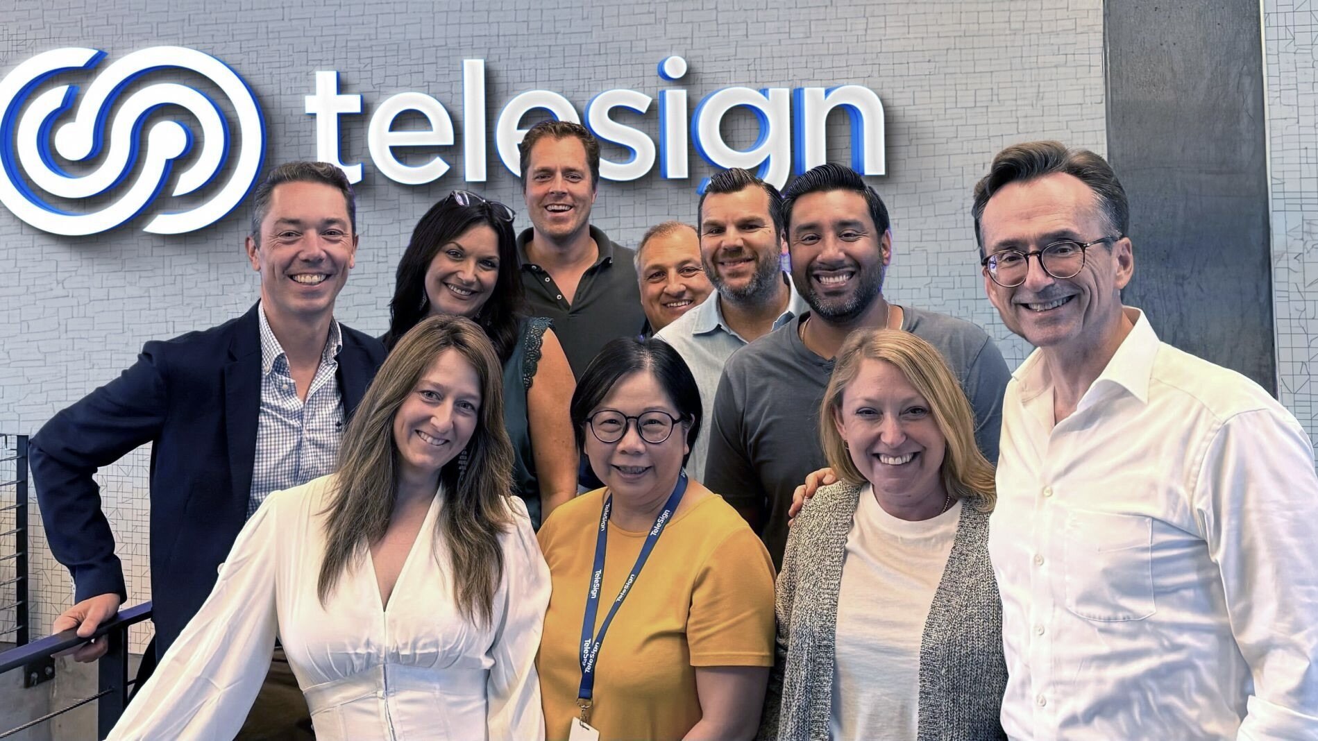 Christophe Van de Weyer, at left, standing with Telesign colleagues in front of the company sign