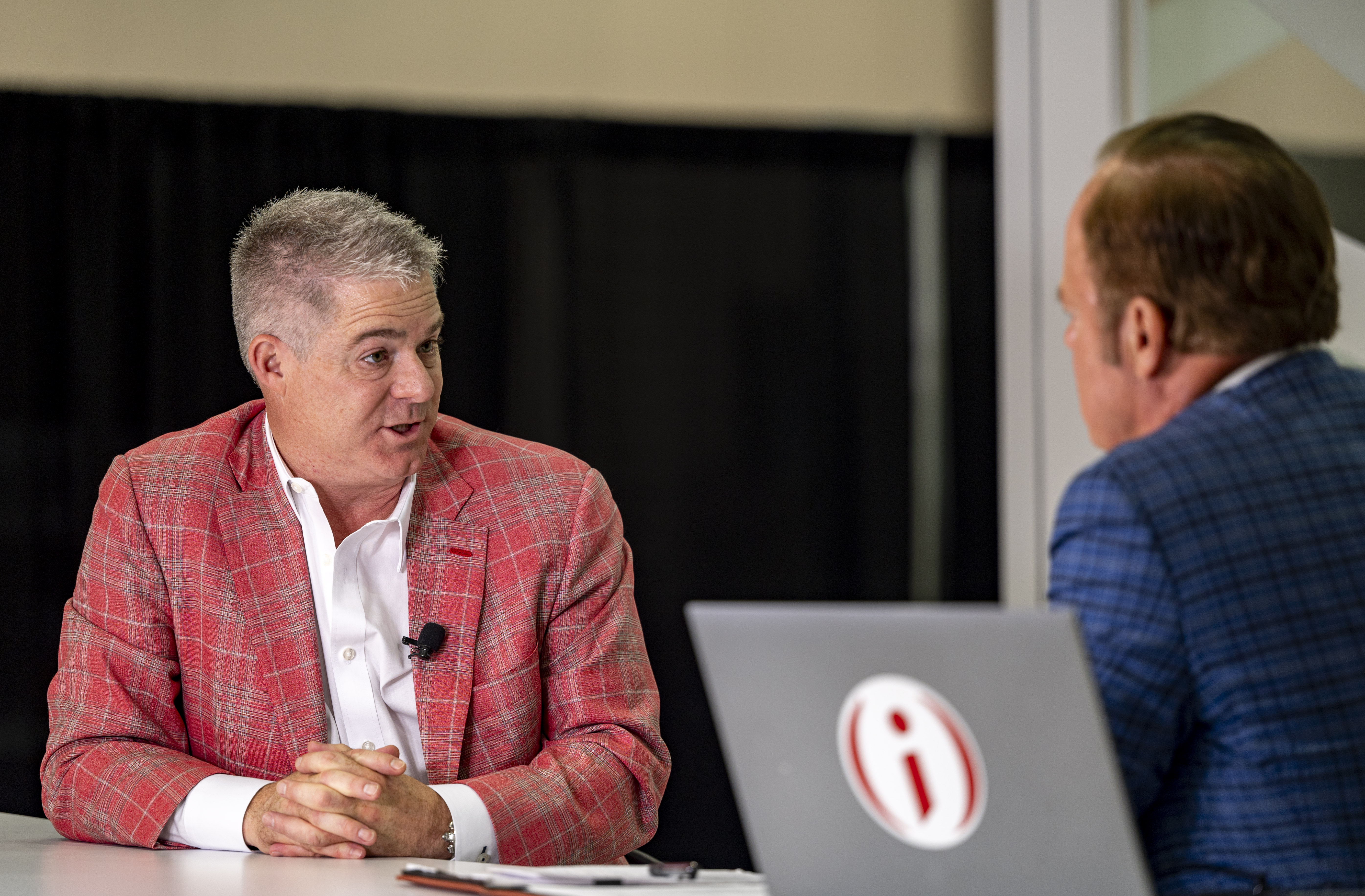 Christopher Day in a red checked jacket speaking with Gerry Dick at Rally in Indianapolis in August 2023.