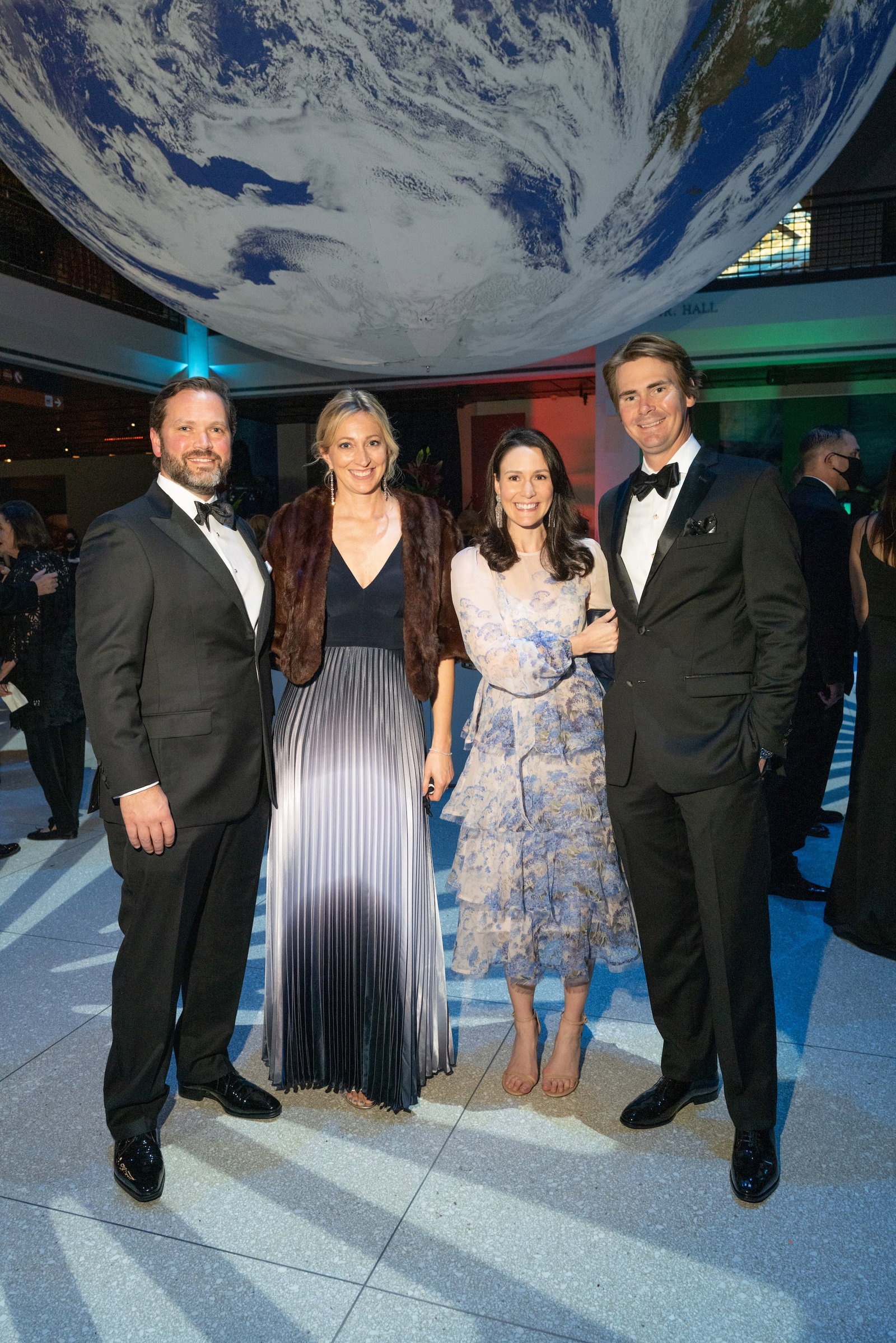 Christopher and Andrea Dvorachek with Callie and Andy Gaines beneath a suspended globe at the Houston Museum of Natural Science gala