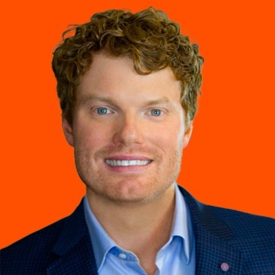 Chris Lynch in a blue jacket against a bright orange background