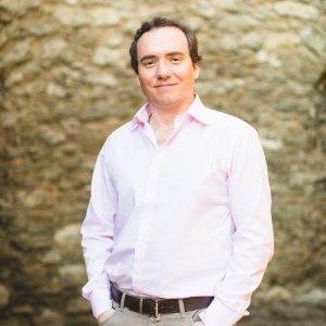 Christopher Padfield standing outdoors in front of a stone wall