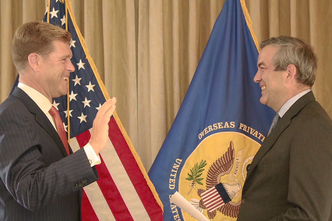 Christopher Vincze, left, raises his right hand as David Bohigian administers the oath for OPIC board service.