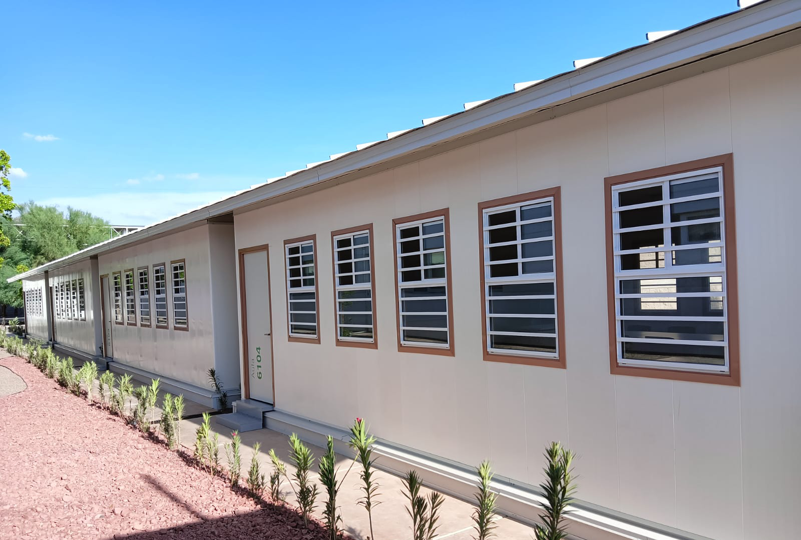 Exterior of modular classroom buildings with repeated windows and pale wall panels