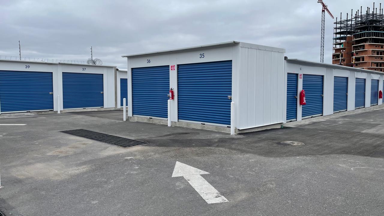Ciinova storage units with blue roll-up doors arranged along a paved access lane