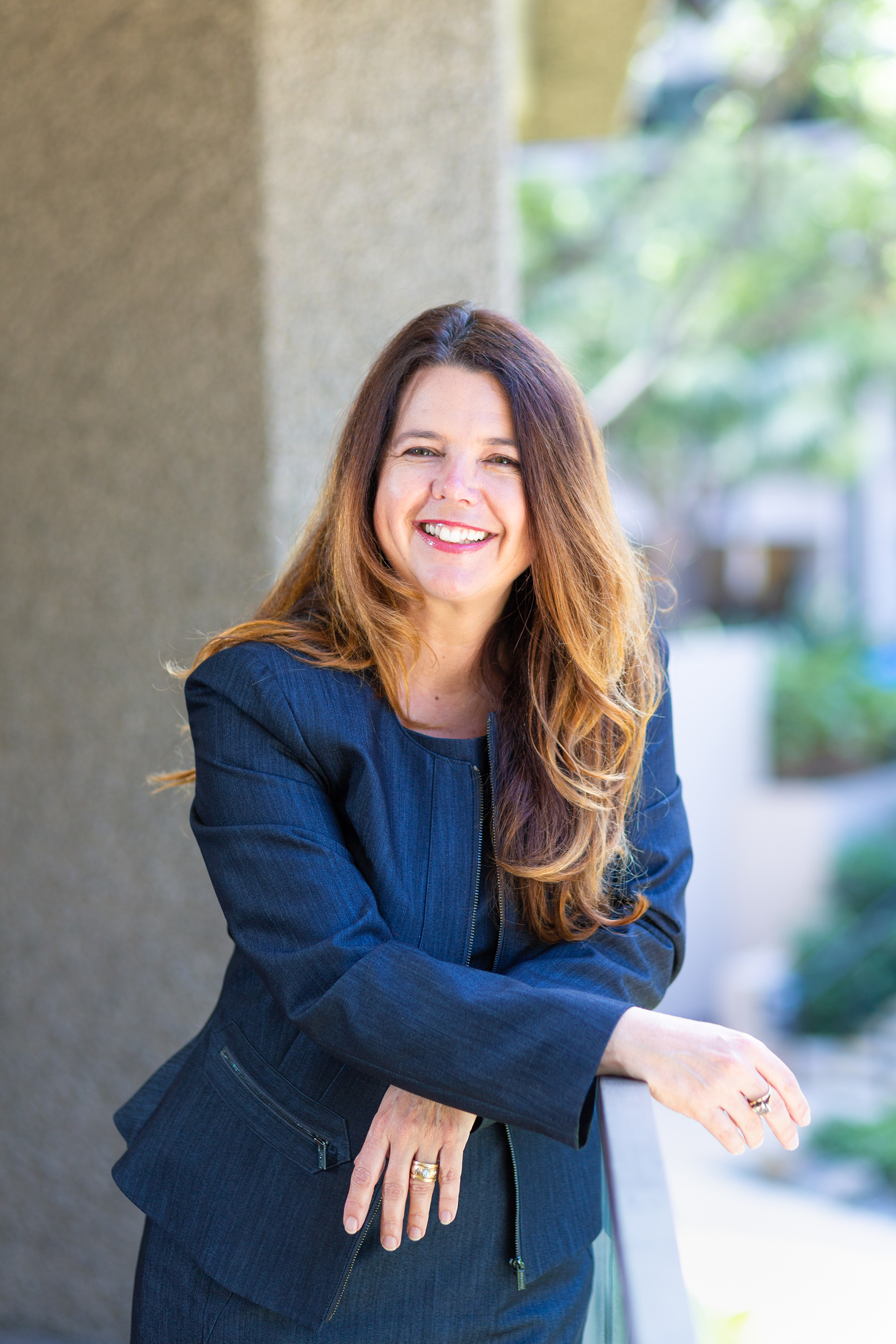 Cindy White standing on a balcony in a navy suit