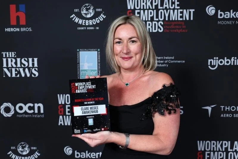 Clare McGee holding her 2025 Business Leader of the Year award