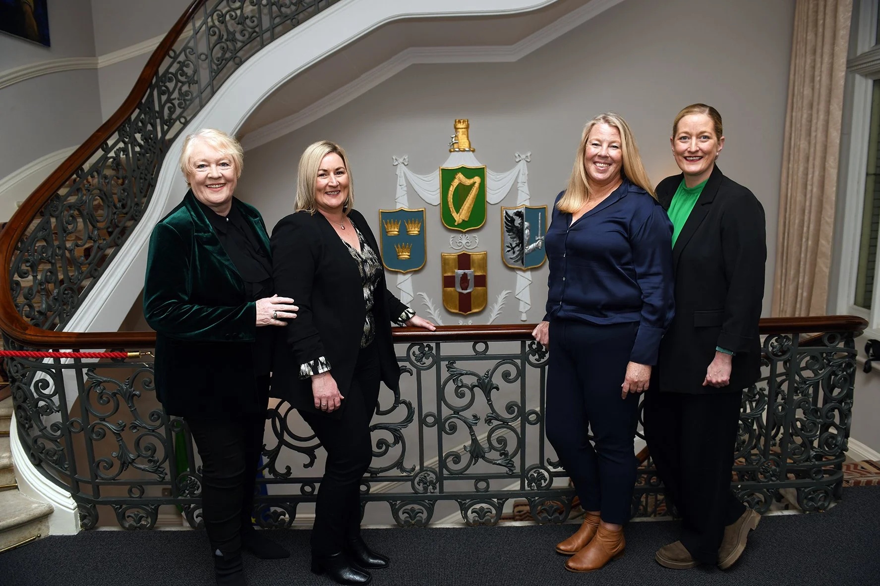 Four AwakenHub co-founders standing together beside a staircase