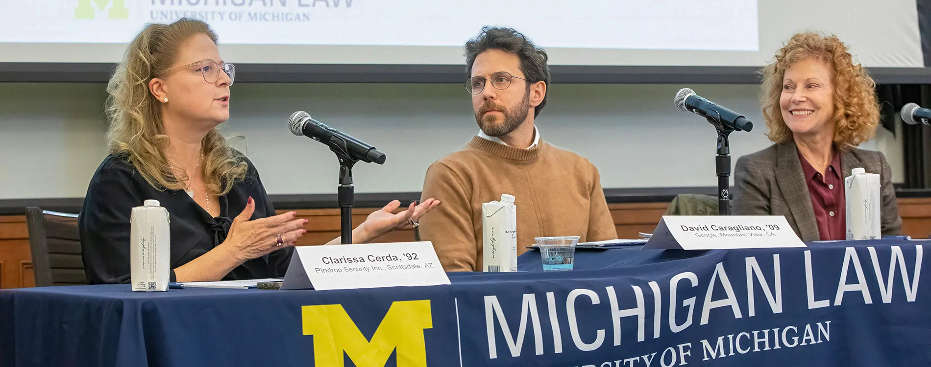 Clarissa Cerda speaking on an AI and law panel at the University of Michigan Law School, seated beside David Caragliano and Mary Snapp