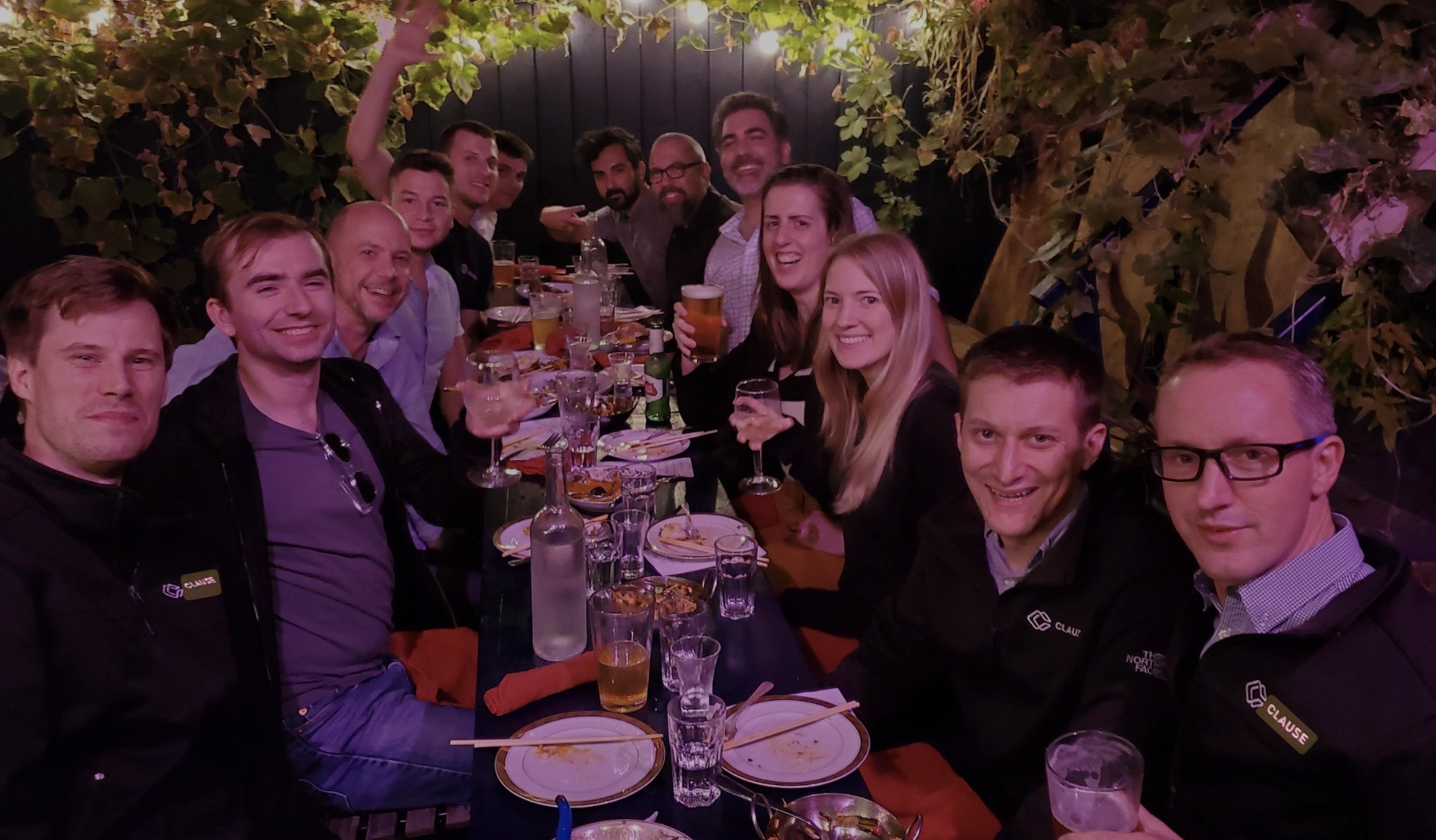 Members of the Clause team gathered around a restaurant table