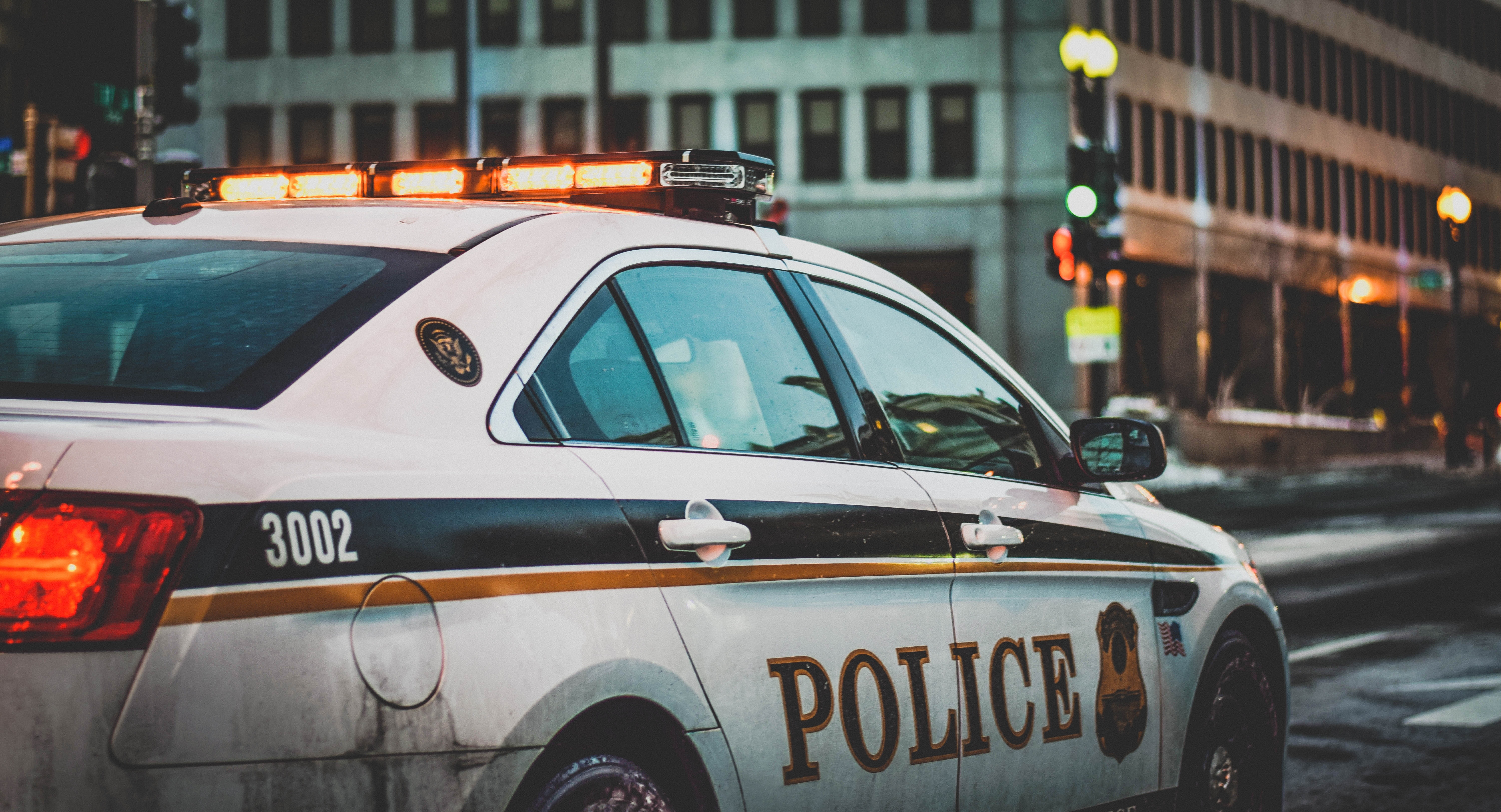 Police car with illuminated roof lights on a city street