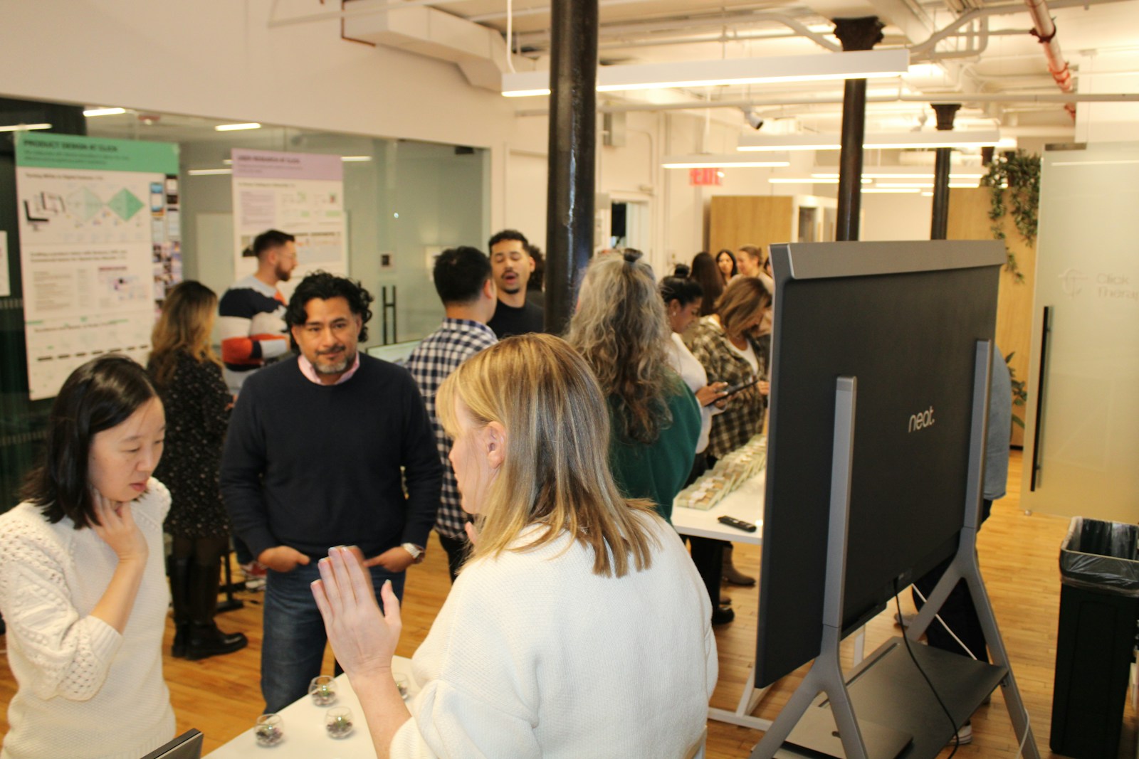 Click Therapeutics colleagues gathered in the office with research posters in the background