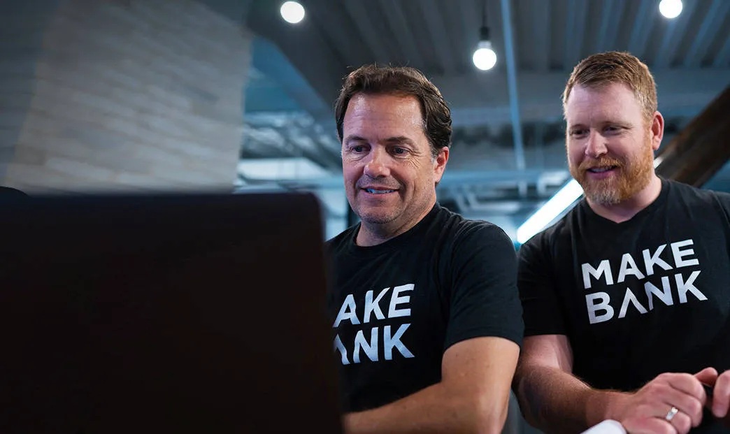 Two ClickBank colleagues looking at a computer in the office