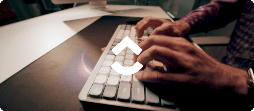 Hands typing at a keyboard beneath the white ClickUp symbol