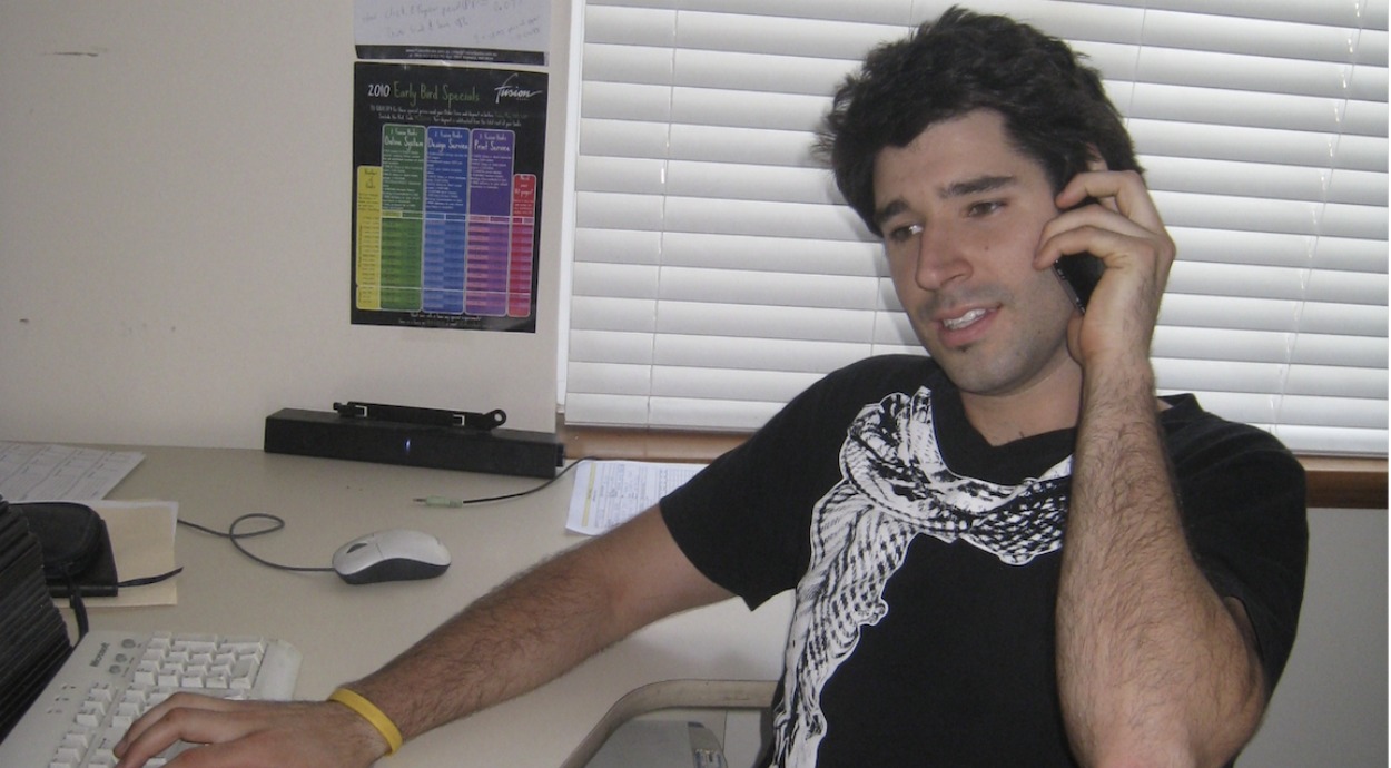 A young Cliff Obrecht calling schools from the Fusion Books office