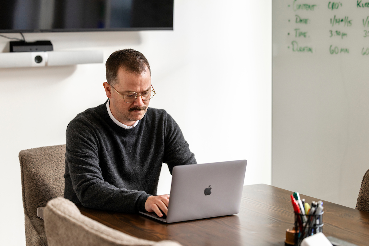 Clint Betts working at a laptop at a meeting table