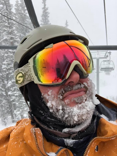 Clint Tasset wearing a ski helmet and reflective goggles, with snow on his beard