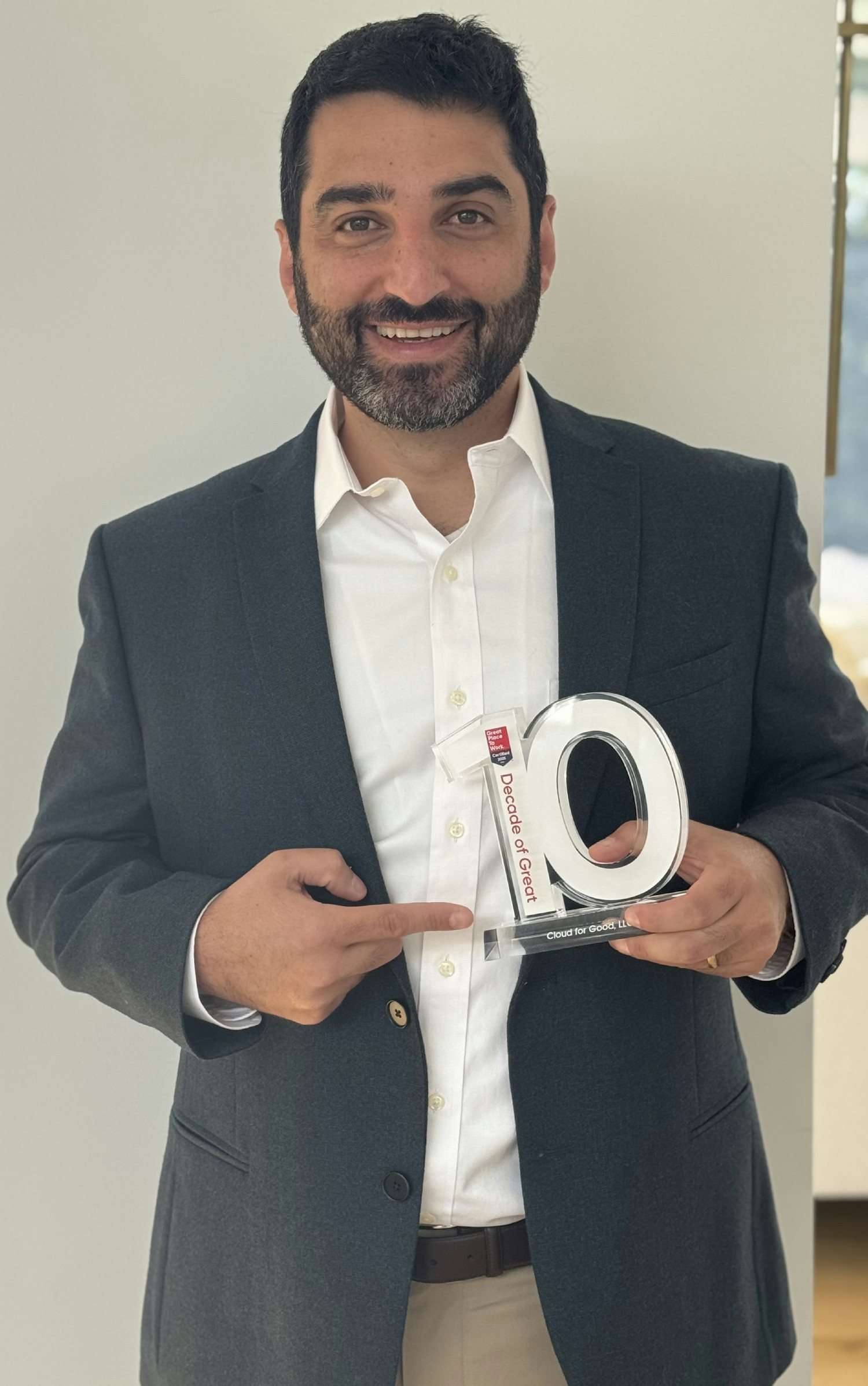 Cloud for Good founder Tal Frankfurt holding a Decade of Great workplace award