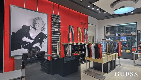 Interior of a Guess retail store with apparel displays